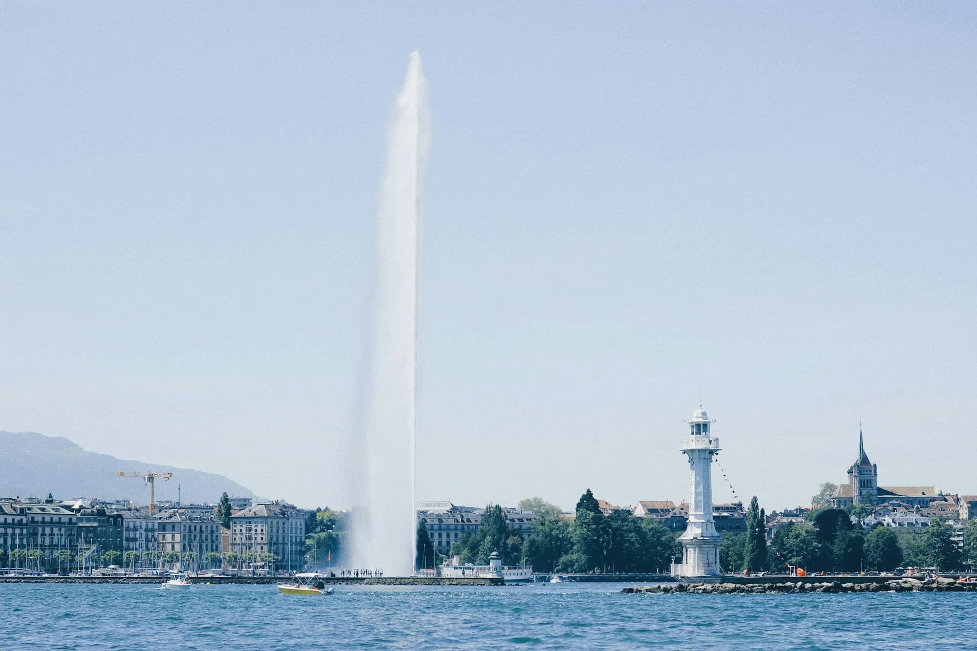 Le jet d'eau de Genève et le phare des Pâquis sur la rade, par temps clair.