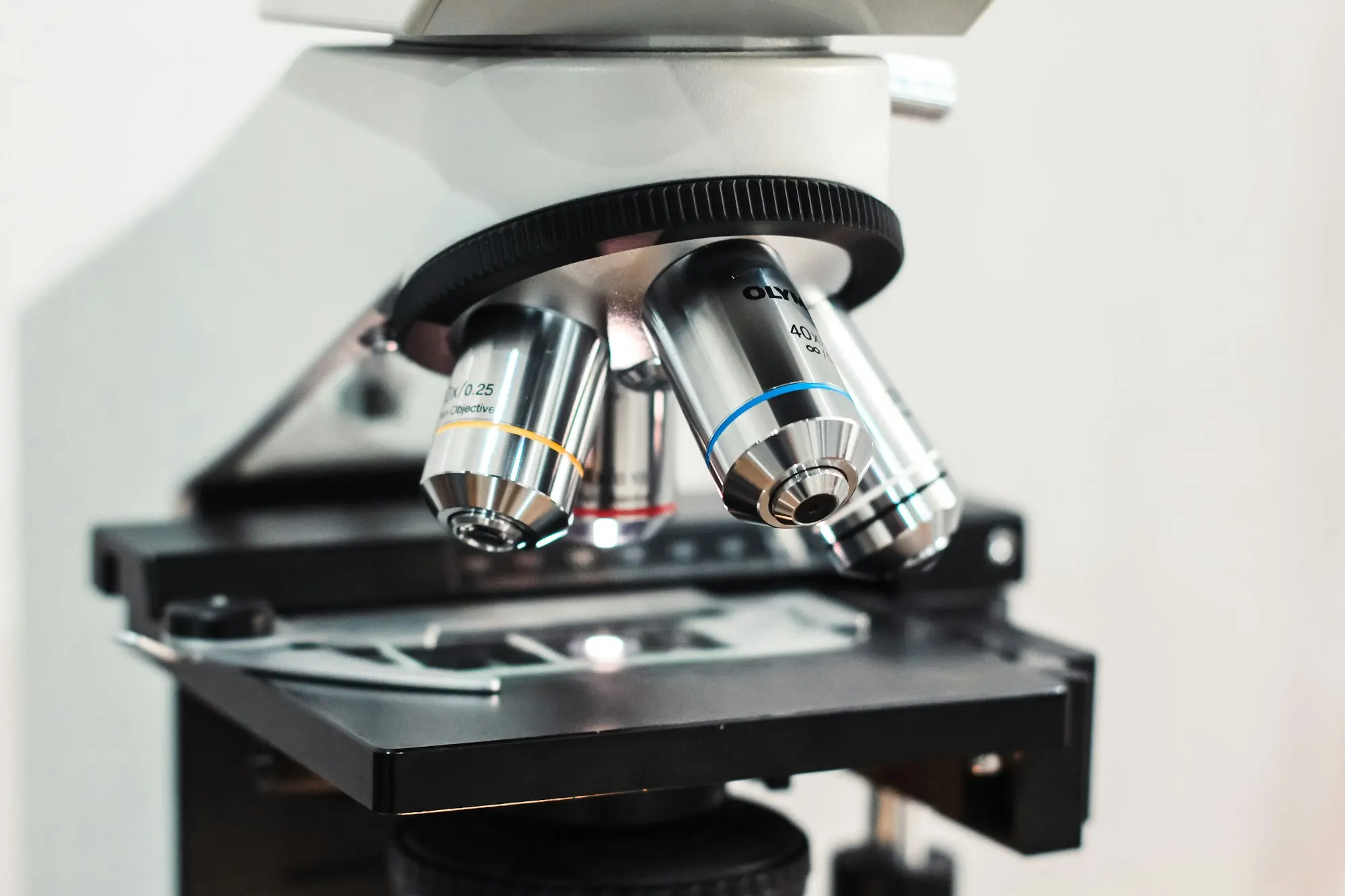 Gros plan sur les objectifs d'un microscope de laboratoire au-dessus d'une lame.